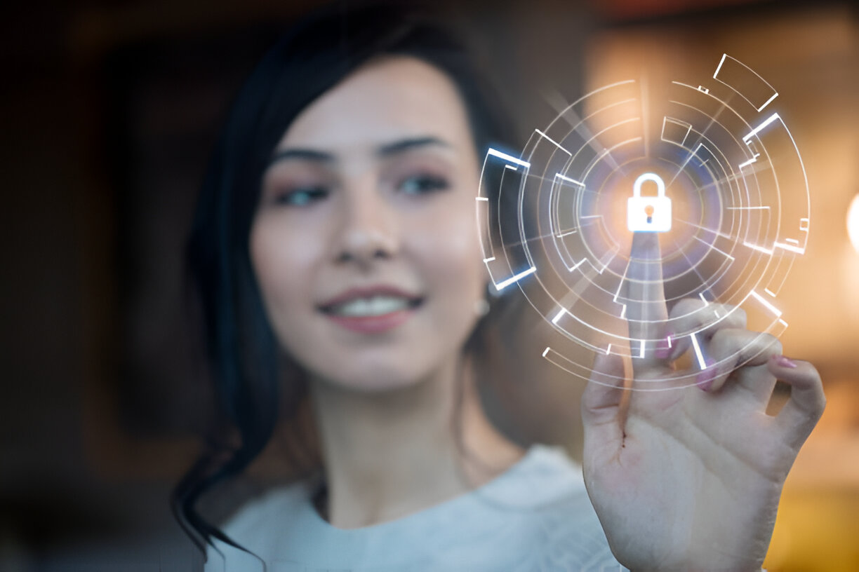 Smiling cybersecurity professional touching a virtual padlock icon on a digital interface symbolizing data protection and secure access.